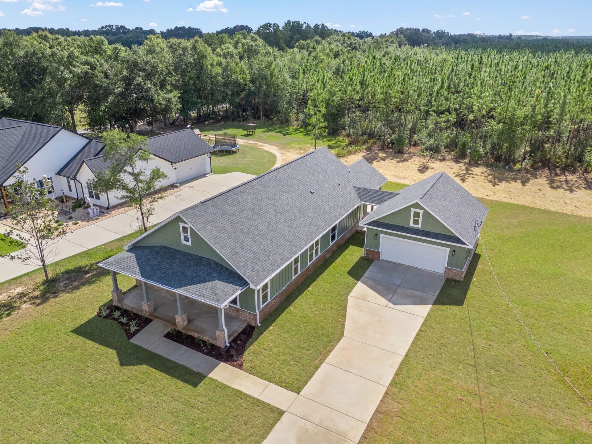 Aerial view of The Ashley on its lot with a detached garage and a long drive