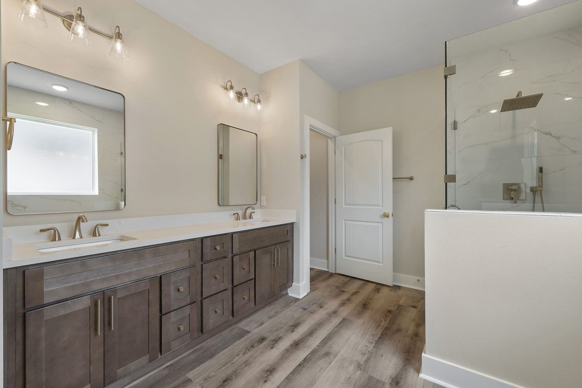 The Ashley primary bath with a stained double vanity and a glass walk-in shower