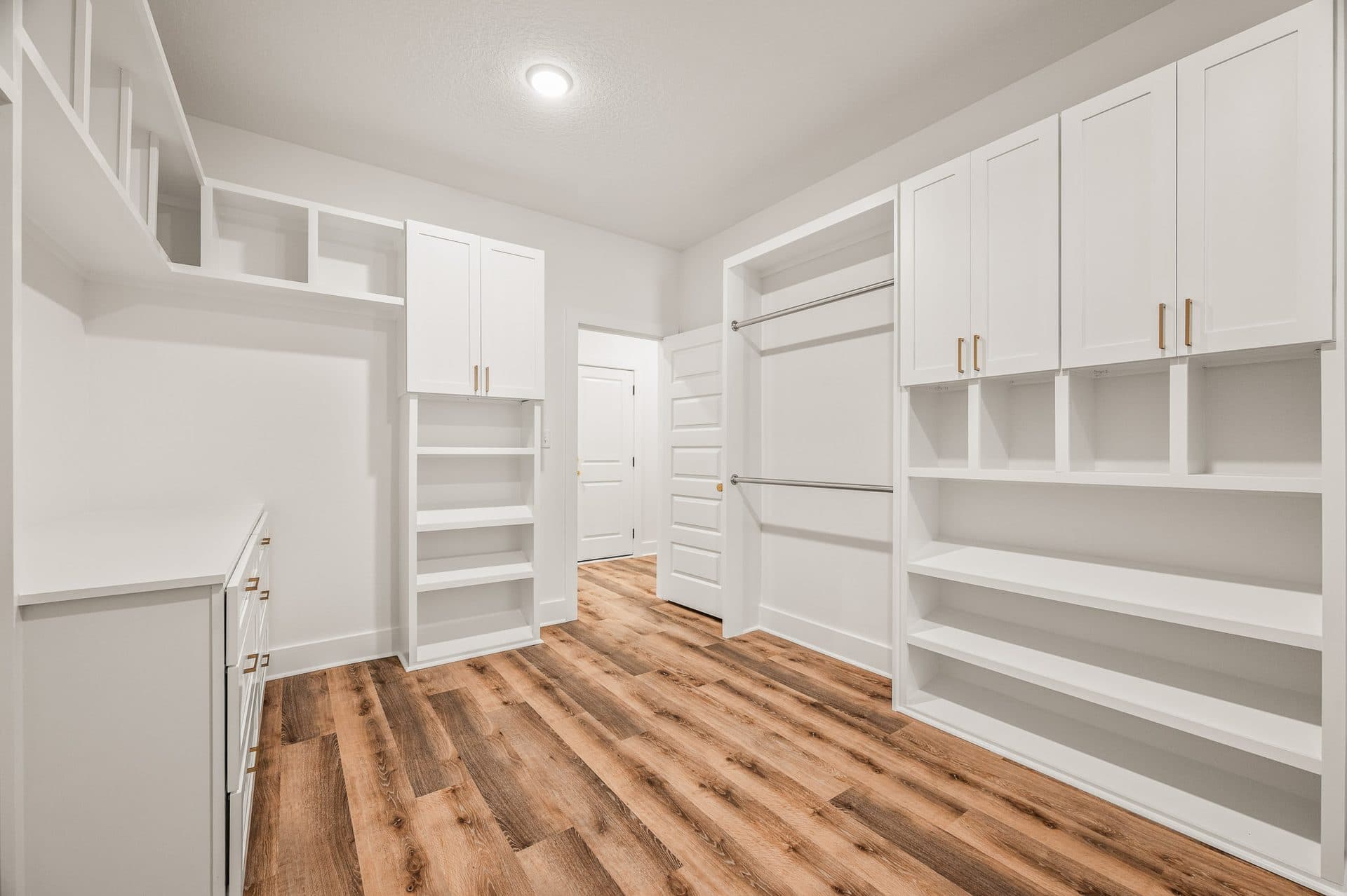 The fitted walk-in closet in The Cameron, with hanging rods, drawers and open shelving