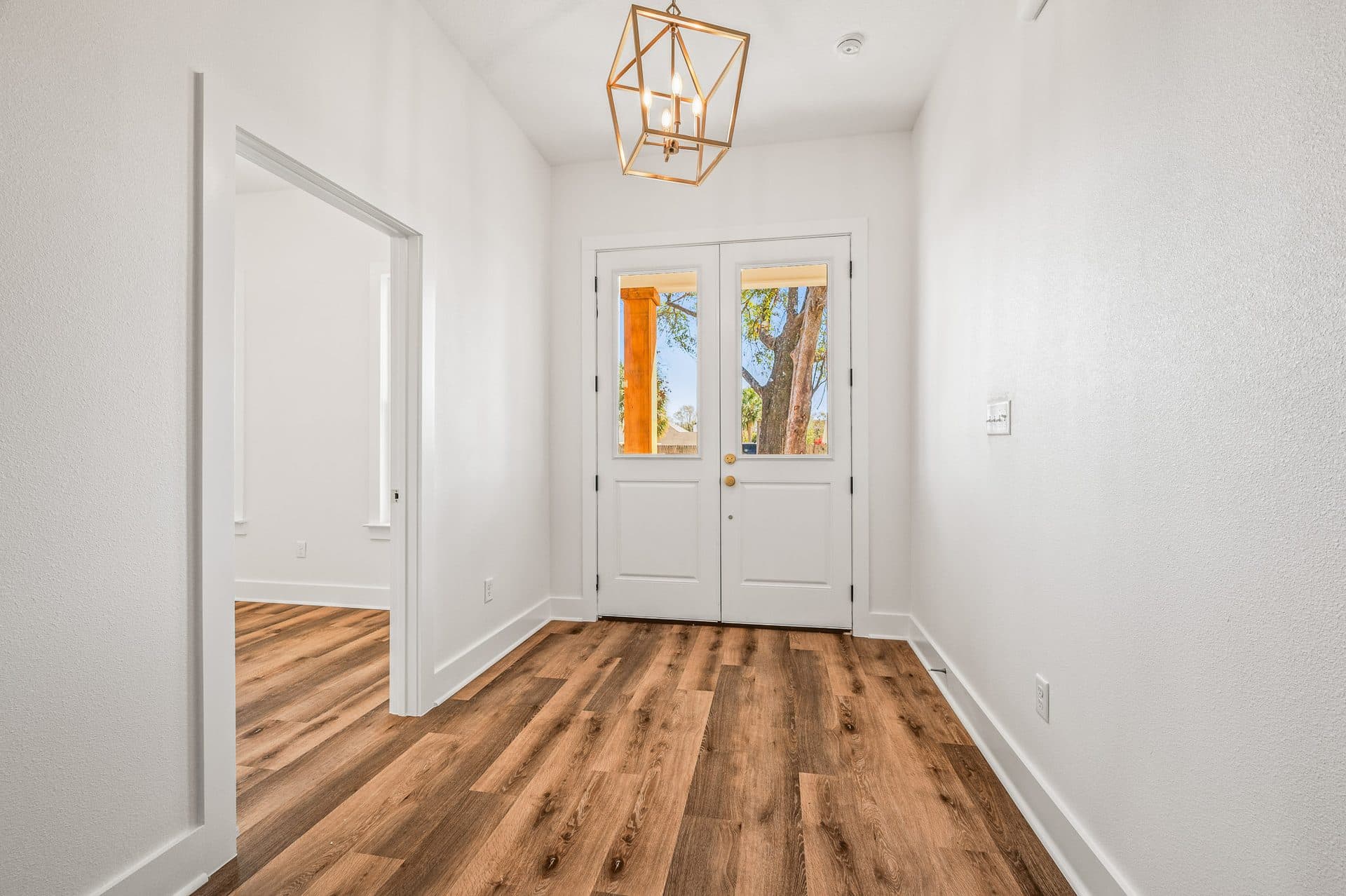 The Cameron foyer with a lantern pendant and glass double front doors