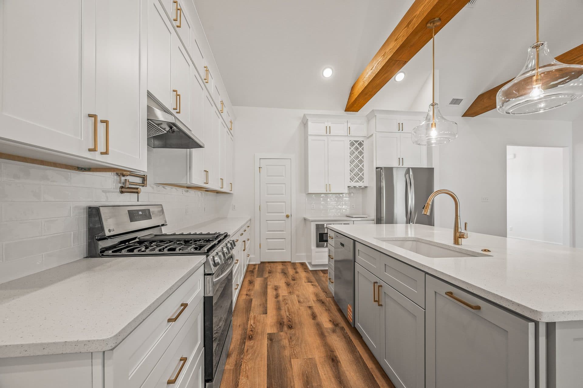 The Cameron kitchen with white shaker uppers, a grey island and champagne bronze hardware